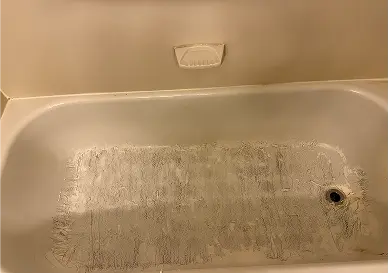 Outdated bathtub showing yellowing and surface damage before reglazing