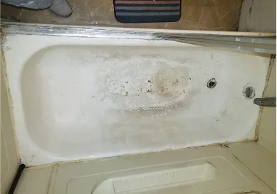 Damaged bathtub showing cracks and dull surface before reglazing