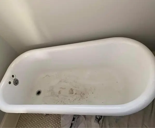 Vintage clawfoot bathtub before reglazing with faded and chipped enamel surface